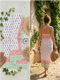 paréo sur fond blanc avec des motifs orange et des rayures vertes bordant le paréo