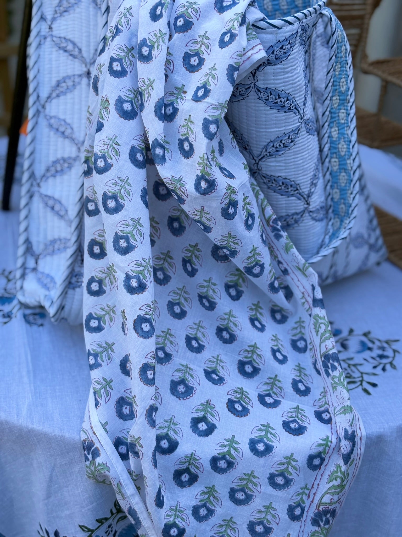 Foulard chardon bleu sur fond blanc posé à moitié dans un sac bleu et blanc
