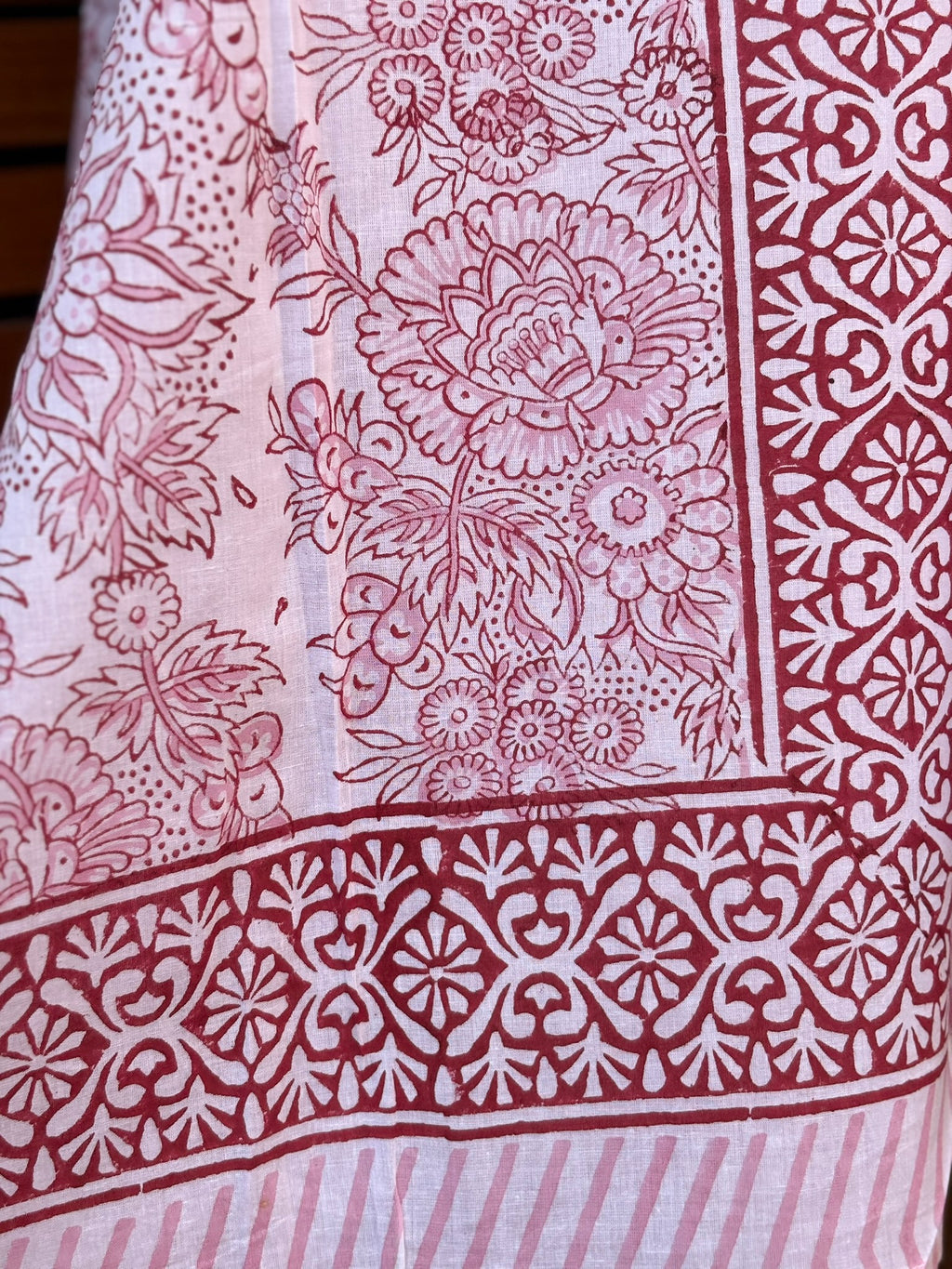 Paréo en coton léger avec impression artisanale indienne de type block print, présentant un motif floral complexe et une large bordure ornementale géométrique de couleur rouge écarlate sur fond blanc. 